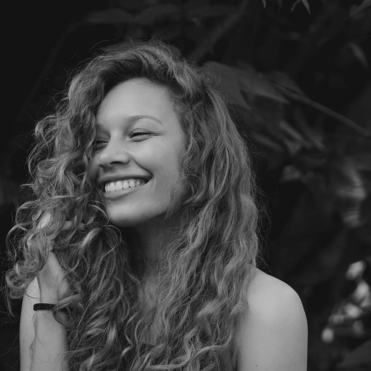Donna sorridente con capelli ricci sani